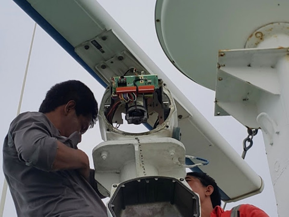 A marine technician repairing radar on a ship